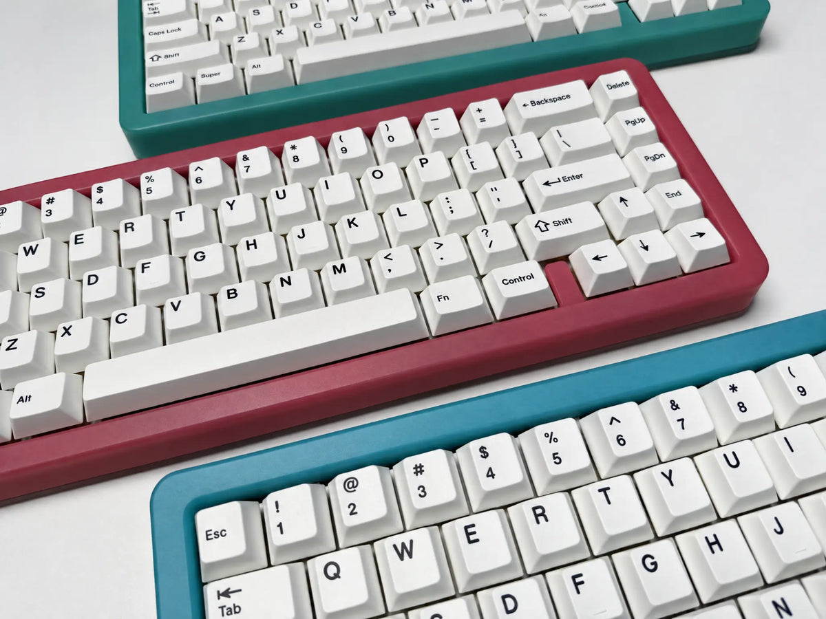 Odin Gaming Aurora65 LITE keyboards in three colors, close angled group view showing case edges and white keycaps.